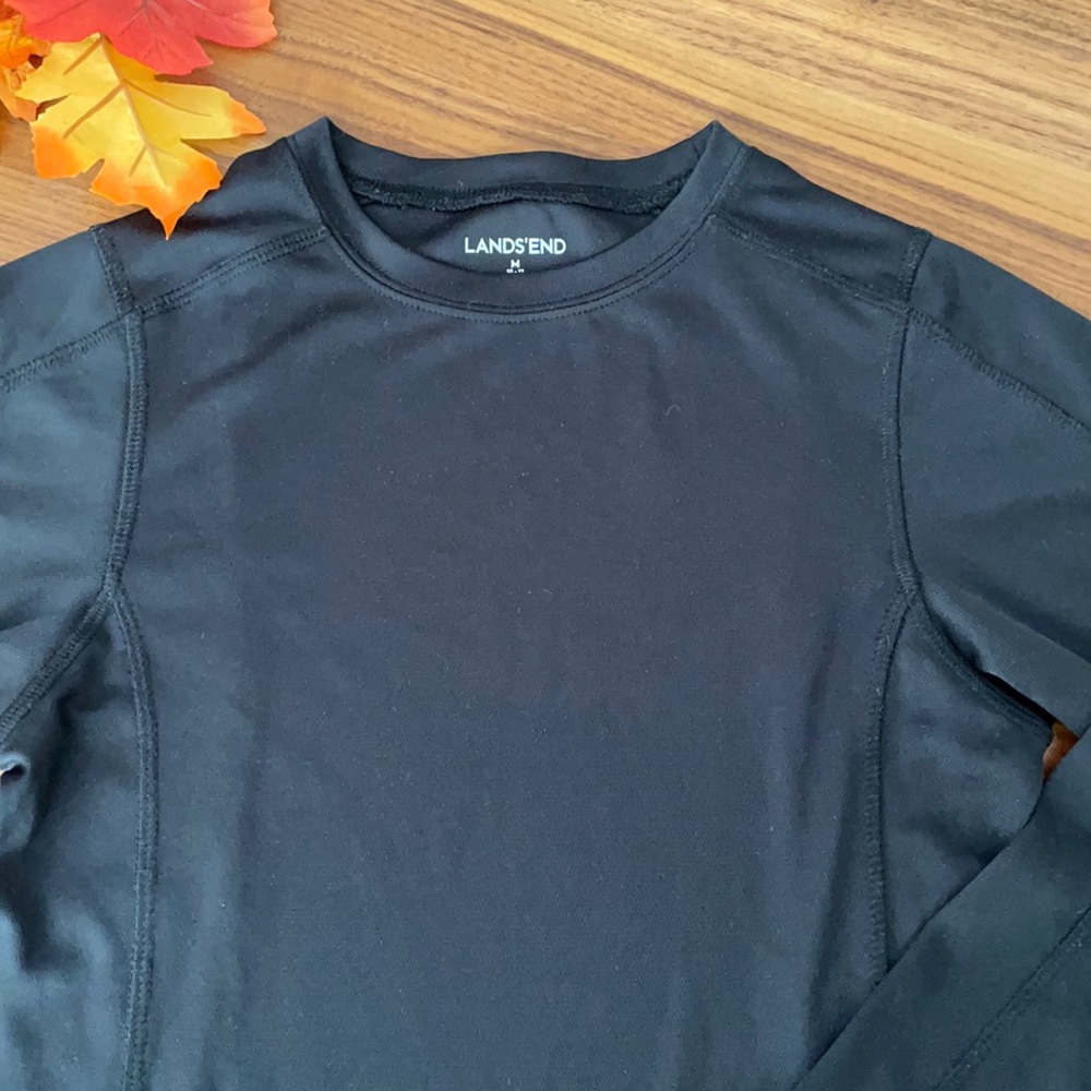 Girls’ black athletic shirt. Long sleeve. Curved back hem. Size 10-12 (M).
